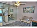 Bright living area featuring a mirrored wall, ceiling fan, and cozy seating at 20893 Haulover Cv # 8, Lutz, FL 33558