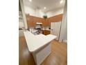 Well-lit kitchen featuring sleek countertops, wood cabinets, modern appliances, and a functional layout at 2931 Walnut Grove Ct, Holiday, FL 34691
