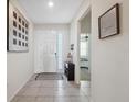 Bright entryway featuring tile flooring, neutral decor, and a view into the adjacent bedroom at 3667 Autumn Amber Dr, Spring Hill, FL 34609