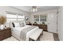 Cozy bedroom with large windows, a comfortable bed, and a neutral color scheme at 3806 River Oaks Ct, New Port Richey, FL 34655