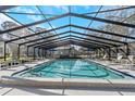Large screened-in pool area with ample seating and a sparkling pool for outdoor relaxation and entertainment at 3806 River Oaks Ct, New Port Richey, FL 34655