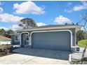 Attached two-car garage with a blue door complements this well-maintained single-story home at 4206 Candler Ave, Spring Hill, FL 34609