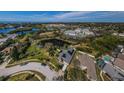 Expansive aerial view of a neighborhood with lake views and solar panels on the roof at 494 Village Dr, Tarpon Springs, FL 34689