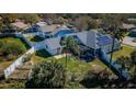 A lush backyard features a covered patio, and solar panels above at 494 Village Dr, Tarpon Springs, FL 34689