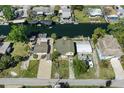 An aerial perspective of a canal-front property, featuring a paved driveway, boat dock, and mature trees at 5319 Ray Dr, Weeki Wachee, FL 34607