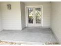 Covered entryway featuring double doors with decorative glass and a patterned concrete porch at 7106 Green Abbey Way, Spring Hill, FL 34606