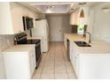 Modern kitchen with white cabinets, stainless steel appliances, and quartz countertops at 7106 Green Abbey Way, Spring Hill, FL 34606