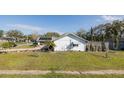 Charming home exterior showcasing a well-kept lawn, white siding and a cozy residential setting at 7931 Rusty Oak Dr, New Port Richey, FL 34653