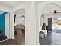 Open hallway with arched doorways, connecting the living spaces with modern flooring at 9291 Geranium Ave, Spring Hill, FL 34606