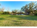 A grassy backyard features a pond and mature trees at 9512 Sunshine Blvd, New Port Richey, FL 34654