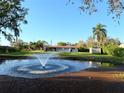 Exterior view of home overlooking a pond with a water fountain and beautiful landscaping at 9512 Sunshine Blvd, New Port Richey, FL 34654