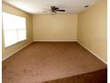 Spacious living room with neutral-toned walls, large window, and plush carpeting at 10020 Vancouver Rd, Spring Hill, FL 34608