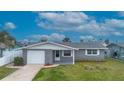 Charming single-story home with gray brick accents, a well-manicured lawn, and an attached garage at 13700 Maria Dr, Hudson, FL 34667