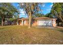 Single-story home featuring stucco exterior, well-manicured lawn, driveway, and a convenient two-car garage at 16422 Monteverde Dr, Spring Hill, FL 34610