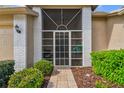 Inviting front porch with tiled floor, screen door and decorative brick accents at 18129 Baywood Forest Dr, Hudson, FL 34667