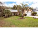 Inviting single-story home featuring a well-manicured lawn, mature trees, and a spacious front yard at 2641 Royal Ridge Dr, Spring Hill, FL 34606