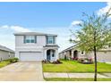 Daytime view of a well-maintained two-story home with a green lawn and neat landscaping at 30845 Penny Surf Loop, Wesley Chapel, FL 33545