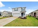Well-kept home boasts a neatly landscaped lawn, attached garage, and a welcoming front entrance at 30845 Penny Surf Loop, Wesley Chapel, FL 33545