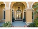 Elegant front entrance with double doors, arched entryway, tile floor, and lush landscaping at 370 Tall Oak Trl, Tarpon Springs, FL 34688
