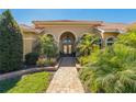 Charming front entrance with double doors, arched entryway, and lush landscaping at 370 Tall Oak Trl, Tarpon Springs, FL 34688