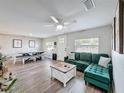 Bright living room with a green sofa, ceiling fan, wood floors and dining area at 4540 52 N Ave, St Petersburg, FL 33714