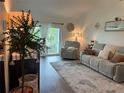 Inviting living room featuring a plush sofa, accent chair, and balcony access, perfect for relaxing or entertaining at 4925 Myrtle Oak Dr # 22, New Port Richey, FL 34653