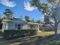 Side view of a well kept home with a beautiful sky backdrop and manicured lawn at 7028 Merrick Ln, Spring Hill, FL 34606