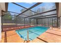 Screened pool with patio and backyard with trees provides a relaxing and private outdoor oasis at 7048 Oberon Ave, Spring Hill, FL 34608