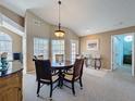 Bright dining area featuring carpet flooring, vaulted ceiling, and elegant furnishings for comfortable entertaining at 7912 Trail Run Loop, New Port Richey, FL 34653