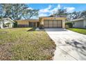 Charming single-story home with a well-maintained lawn and a two-car garage at 8420 Winding Wood Dr, Port Richey, FL 34668