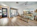 Bright living room featuring wood floors, floral-patterned furniture, and a ceiling fan at 8420 Winding Wood Dr, Port Richey, FL 34668