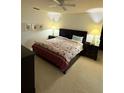 Comfortable bedroom with ceiling fan, neutral carpet, and side tables at 11121 Linkside Dr # 11121, Port Richey, FL 34668