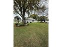 Large grassy backyard surrounded by mature trees and manicured landscaping at 11121 Linkside Dr # 11121, Port Richey, FL 34668