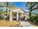 Charming two-story home featuring an inviting front porch, well-maintained landscaping, and mature trees, creating a picturesque setting at 120 Read St, Tarpon Springs, FL 34689