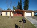 Charming single-story home with a well-maintained front yard and mature trees on a sunny day at 12716 Mulberry Ln, Hudson, FL 34667