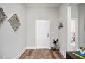 Bright entryway with wood flooring, white door, and decorative wall art, creating a welcoming ambiance at 13186 Road Runner Ave, Weeki Wachee, FL 34614