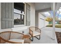 Inviting front porch with wicker furniture, providing a cozy outdoor seating area next to a large window at 13186 Road Runner Ave, Weeki Wachee, FL 34614