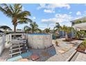 Backyard with inviting above-ground pool, patio space, and lush landscaping, ideal for outdoor entertaining at 13604 Maria Dr, Hudson, FL 34667