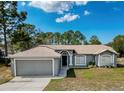 Well maintained home featuring an attached two car garage, arched entryway, and manicured lawn at 2165 Bolger Ave, Spring Hill, FL 34609