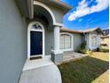 Close up of front door area with covered entrance and beautifully maintained landscaping at 2165 Bolger Ave, Spring Hill, FL 34609