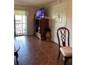 Spacious living area with a TV, balcony access, and tile flooring at 2688 Pine Ridge N Way # D2, Palm Harbor, FL 34684