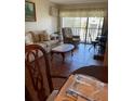 Cozy living room features tile flooring, sofa, recliner, and sliding glass doors with natural light at 2688 Pine Ridge N Way # D2, Palm Harbor, FL 34684