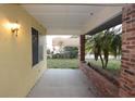 Covered front porch with stucco walls, brick accents, and a view of the surrounding landscape at 29341 Rhodin Pl, Wesley Chapel, FL 33545