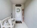 Cozy front porch with welcoming decor, including a bench, pillows, and a decorative 'Welcome' sign at 30886 Satinleaf Run, Brooksville, FL 34602