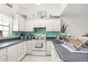 Bright kitchen featuring white cabinetry, ample countertop space, and teal backsplash at 3251 Shoal Line Blvd, Hernando Beach, FL 34607