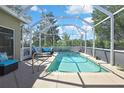 Inviting screened-in pool with comfortable seating, surrounded by lush greenery and open skies at 329 Greenwich Cir, Spring Hill, FL 34609