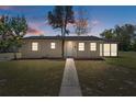 Inviting single-story home with exterior lighting at dusk and manicured lawn at 520 Copperfield Rd, Spring Hill, FL 34606