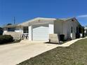 Well-maintained white home featuring a one-car garage and a cozy front patio area at 5441 Mosaic Dr, Holiday, FL 34690