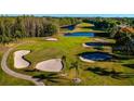 Scenic aerial view of golf course with sand traps and ponds in lush green setting at 5912 Willow Creek Ct, New Port Richey, FL 34655