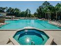 Sparkling community pool surrounded by lounge chairs and lush trees at 5912 Willow Creek Ct, New Port Richey, FL 34655